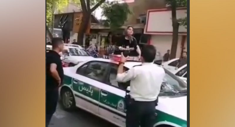 نشستن یک زن روی سقف ماشین پلیس در تهران برای آزادی شوهرش! + ویدیو